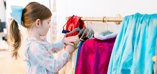 Child Getting Clothes Off Of Rack